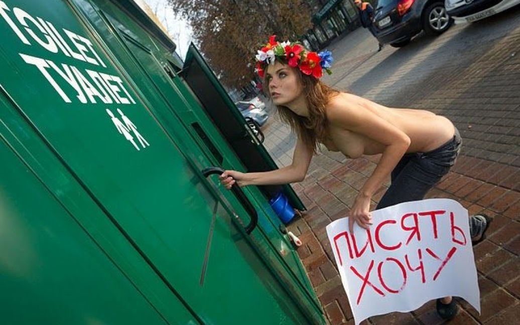 Дівчина ходила в туалет в центрі Києва. В руках вона тримала плакат з написом, який красномовно говорив про причини того, що вона робить. / © femen.livejournal.com