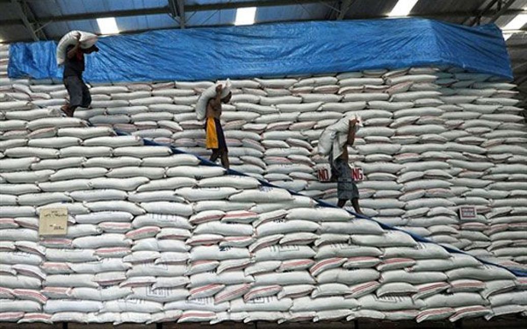 Філіппіни, Маніла. Працівники переносять мішки з рисом на національному продовольчому складі у Манілі. Філіппіни, провідний світовий імпортер рису, заявили, що віддаватимуть 50 тисяч тонн надлишків рису дітям, які голодують. Завдяки цьому також звільниться місце на 480 державних складах, оскільки нещодавно президент Філіппін Беніньо Акіно заявив, що непроданий рис гниє. / © AFP