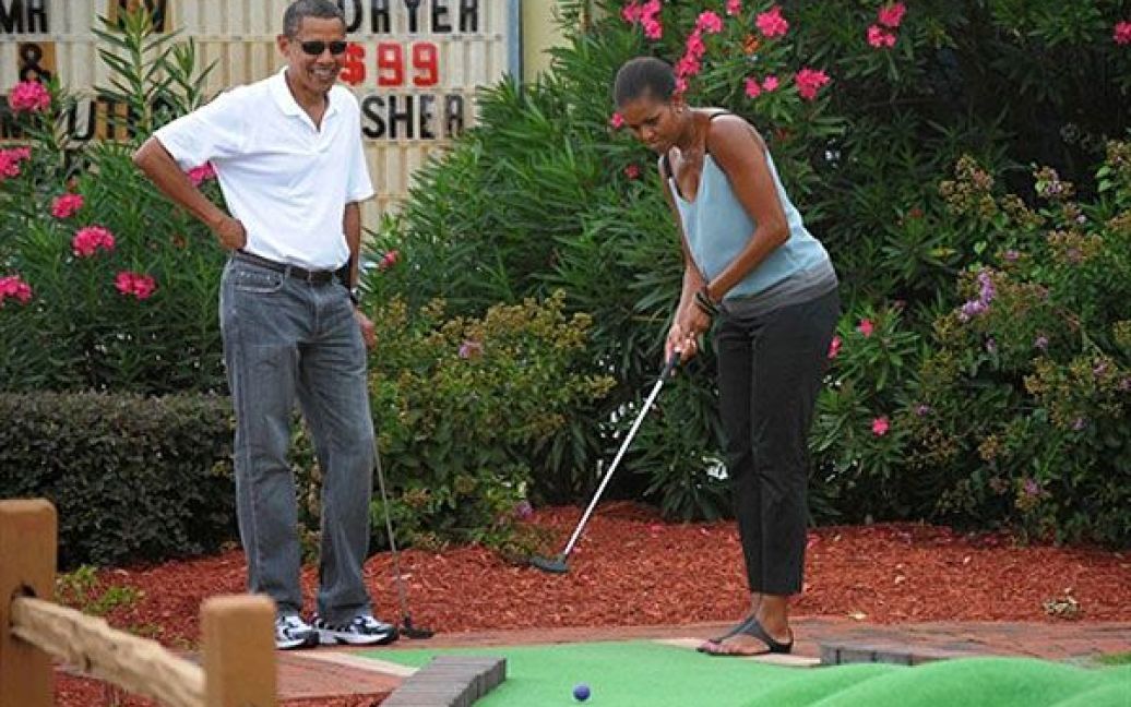 США, Панама Сіті Біч, штат Флорида. Президент США Барак Обама і перша леді США Мішель Обама під час гри у міні-гольф у гольф-центрі "Піратський острів". / © AFP
