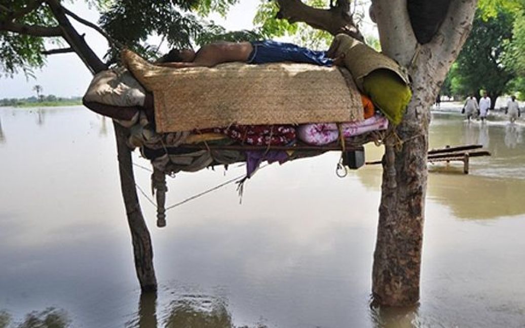 Жертва повені у Пакистані спить у гамаку над водою. За підрахунками ООН, під час повені загинули більше 1600 людей. / © AFP