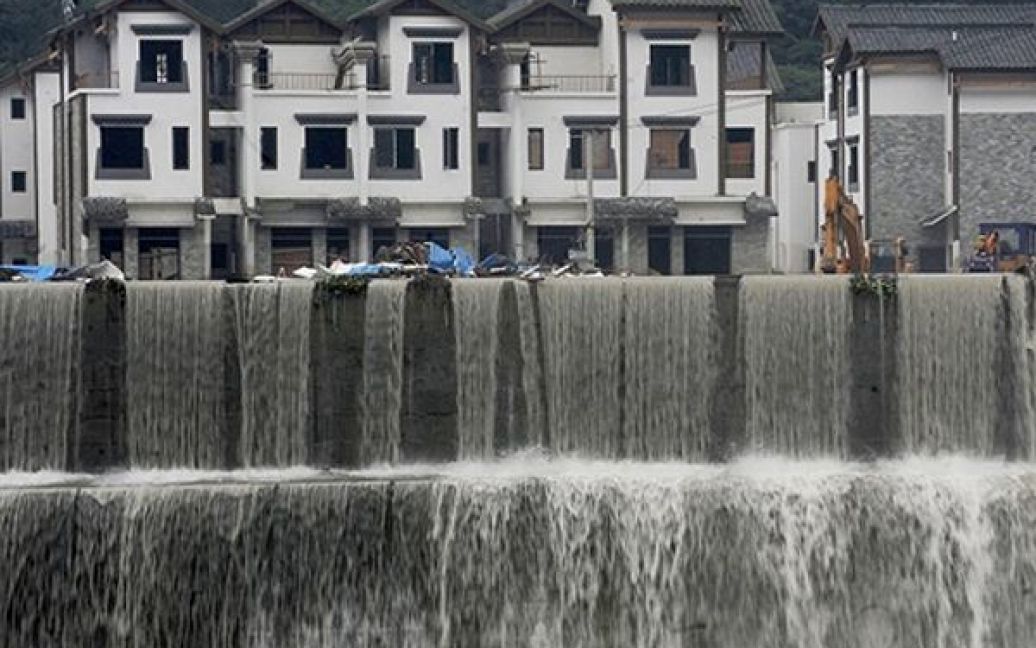 Вода стікає з затоплених вулиці міста Юнчу, яке найбільше постраждало від повені, у китайській провінції Сичуань. Під час зсуву ґрунту, який був викликаний повінню, у Юнчу загинули 15 людей. / © AFP