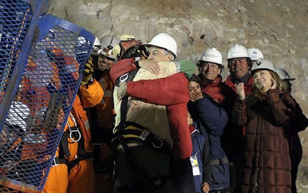 Чилі, Копіапо. Чилійський шахтар Флоренсіо Авалос обнімає президента Чилі Себастьяна Піньєру. У Копіапо триває операція з підняття на поверхню 33 шахтарів, які протягом 10 тижнів перебували у підземній пастці в шахті Сан-Хосе. Флоренсіо був першим з 33 шахтарів, яких піднімають по черзі. / © AFP