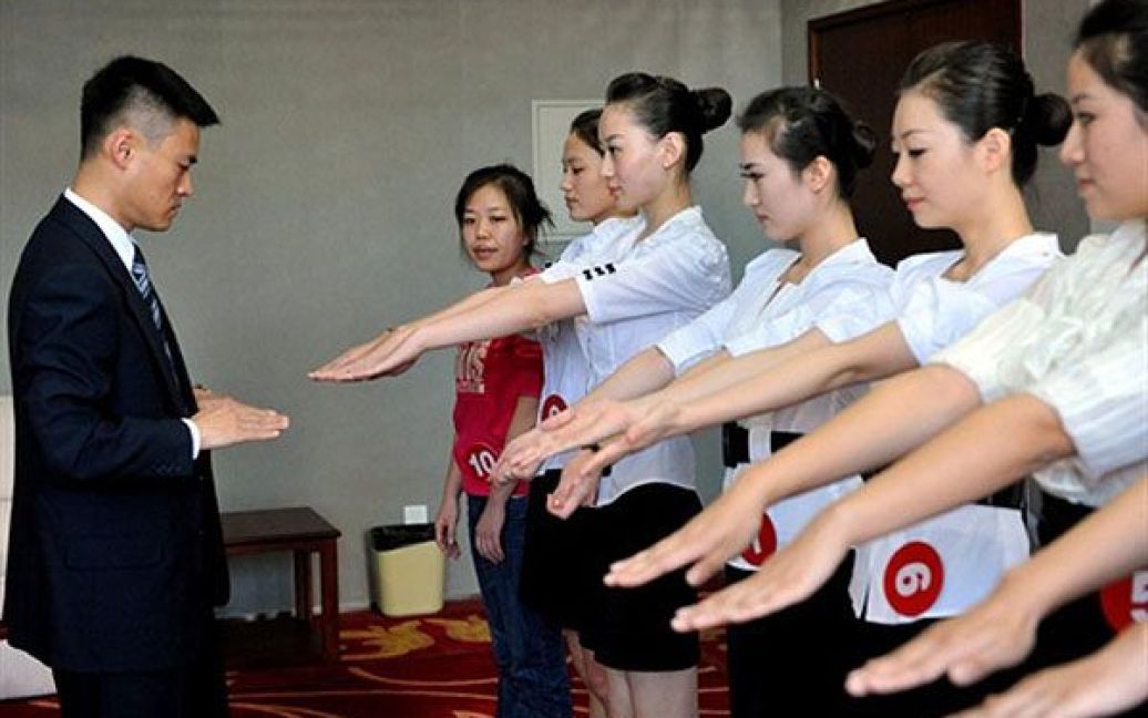 Китай, Пекін. Дівчата демонструють свої руки під час відбору на посаду стюардес у одній з китайських авіакомпаній. Кількість авіакомпаній у Китаї швидко зростає, оскільки попит на повітряні перевезення зростає. Наразі у Китаї нараховують понад 1300 пасажирських літаків. / © AFP