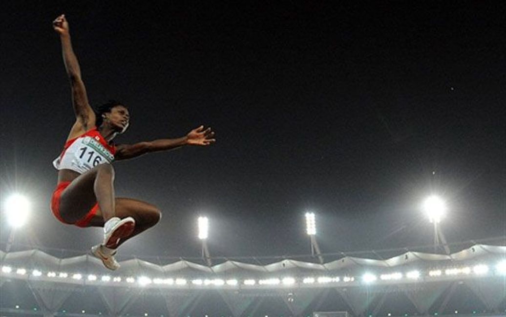 Індія, Нью-Делі. Канадська легкоатлетка Аліса Фалайе виконує стрибок у довжину під час фінальниз змагань з легкої атлетики на Іграх Співдружності у Нью-Делі. Спортсменка стрибнула на 6,50 метрів і виграла "золото". / © AFP