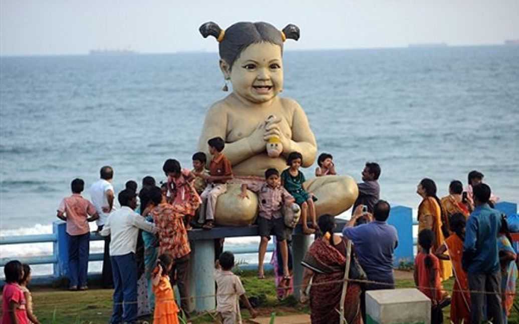 Туристи фотографуються із величезною лялькою на пляжі у Вісакхапатамі, Індія. / © AFP