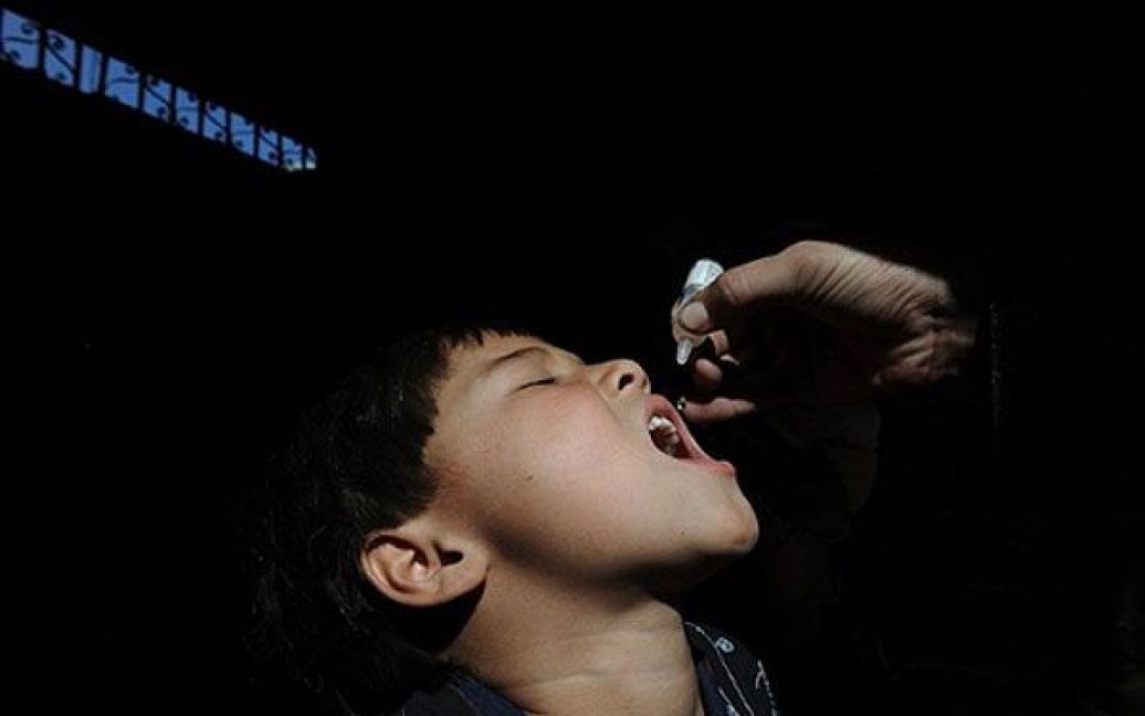 Афганістан, Кабул. Афганських медпрацівник дає дитині вакцину від поліомієліту під час кампанії з вакцинації у Кабулі. В Афганістані проводять триденну загальнонаціональну кампанію імунізації населення проти поліомієліту. / © AFP