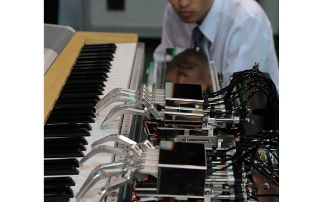 Чоловік спостерігає за грою робота на фортепіано на Виставці роботів у Тайбеї. У виставці взяли участь більше 300 виробників роботів з 66 країн світу. / © AFP