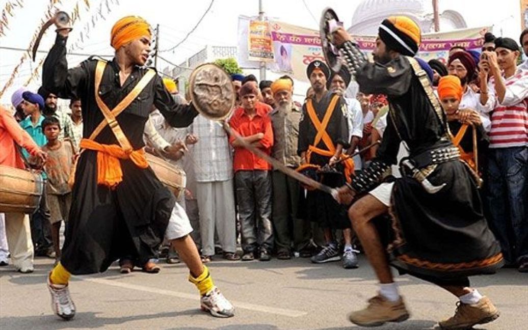 Індія, Амрітсар. Індійські сикхи, одягнені у костюми релігійних воїнів сикхів &ldquo;nihang&rdquo;, демонструють свою майстерність у бойовому мистецтві сикхів, відомому як "gatka&rdquo; під час ходи до Золотого храму в Амрітсарі. В Індії готуються до святкування дня народження четвертого Гуру сикхів Рамдасса, який народився у Лахорі у 1574 році. / © AFP