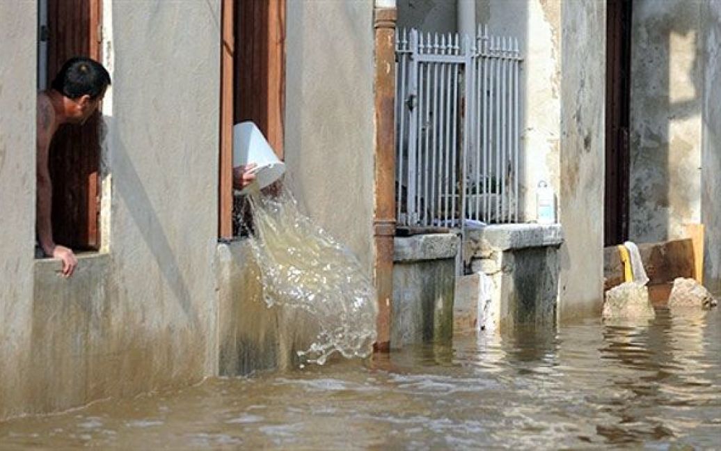 Франція, Сент-Андіоль. Місцеві жителі виливають воду зі свого затопленого будинку у містечку Сент-Андіоль на південному заході Франції. Через сильні зливи і бурю місто залило водою. / © AFP