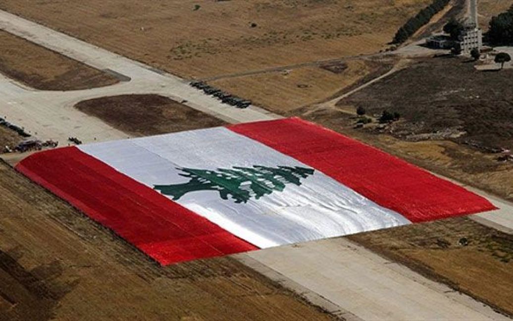 Ліван, Раяк. Військові розгорнули найбільший у світі національний прапор Лівану на авіабазі Раяк у східній частині долини Бекаа. Наразі діючим володарем рекорду Гіннеса з найбільшого національного прапору є Марокко &mdash; розміри їхнього прапору склали 60 тисяч квадратних метрів. Представники ліванських військових заявили, що розмір прапору Лівану, який вони розгорнули, становить 65 тисяч квадратних метрів. Прапор шили у Кувейті, а "збирали" у Лівані. / © AFP