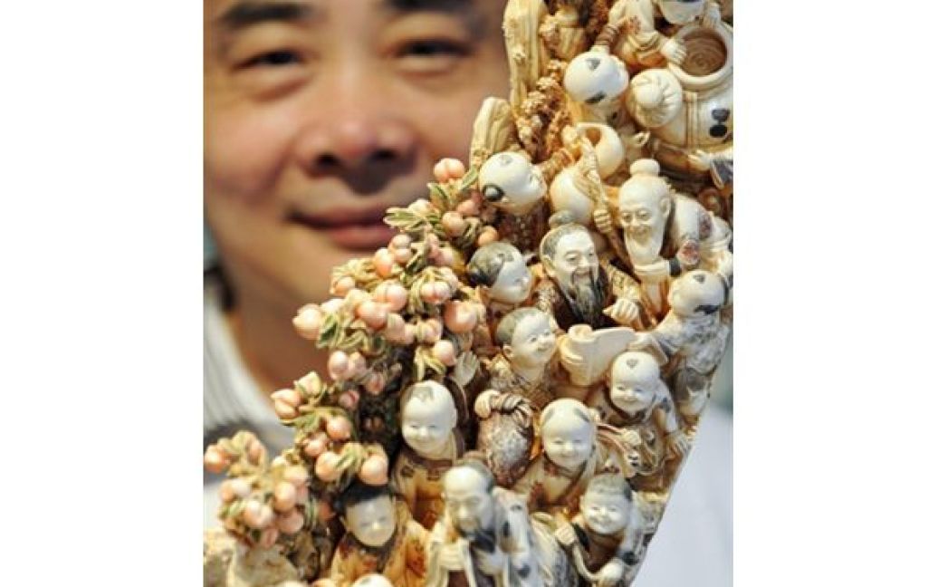 Співробітник китайської ювелірної компанії Prestige Crafts Чу Шінг виставив на аукціон бивень мамонта, вздовж якого вирізані сцени з життя буддистів, китайські пейзажі та навіть еротичні сцени. / © AFP
