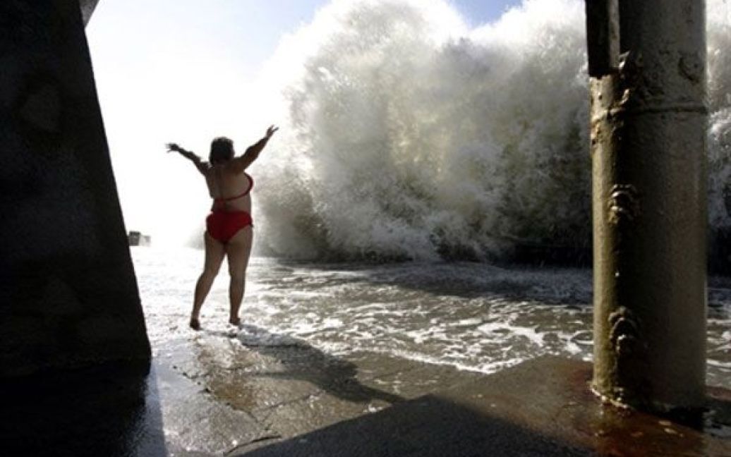 Росія, Сочі. Жінка стоїть перед великою хвилею на чорноморському пляжі у Сочі. / © AFP