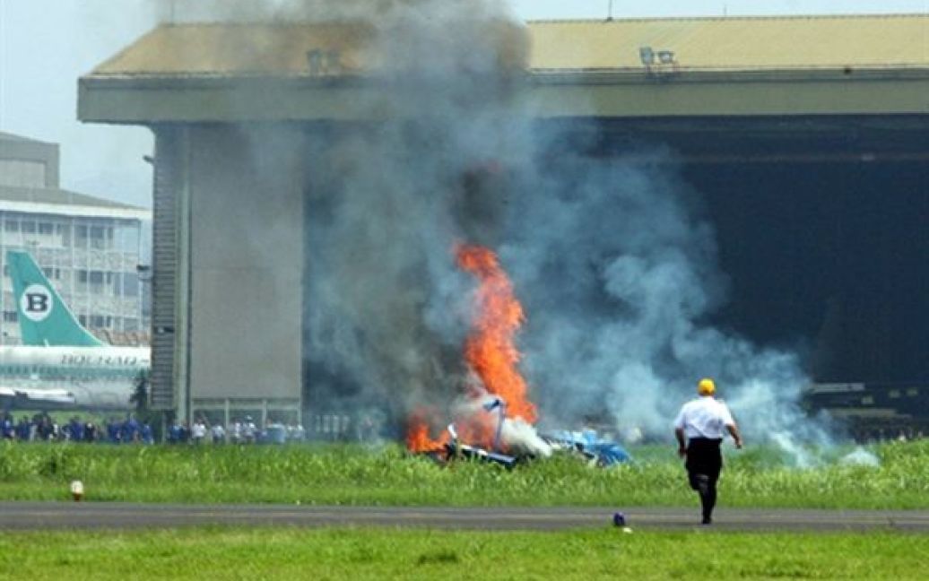 Чоловік біжить на допомогу пілотам літака, який розбився під час авіа-шоу у Бандунзі, Індонезія. За інформацією організаторів шоу, перший пілот літака отримав серйозні травми. / © AFP