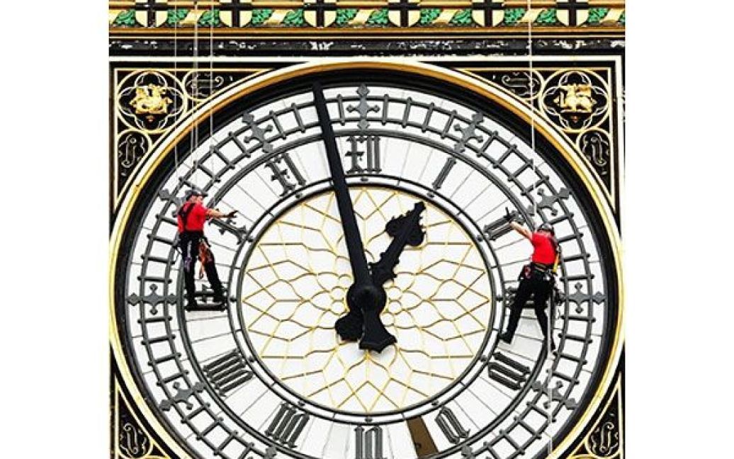 Великобританія, Лондон. Працівники ремонтують циферблат годинника на вежі святого Стефана, також відомій як "Біг Бен", будівлі парламенту у центрі Лондона. / © AFP