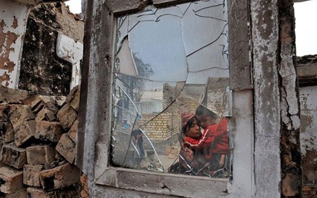 Киргизстан, Ош. Узбецька жінка та її син дивляться на свій зруйнований будинок у селі Шарк неподалік від міста Ош. Сили безпеки у Киргизстані перебувають у стані підвищеної готовності, аби уникнути спалаху насильства напередодні парламентських виборів в країні. Президент Киргизстану Роза Отунбаєва заявила, що країна намагається оправитися від етнічного кровопролиття. / © AFP