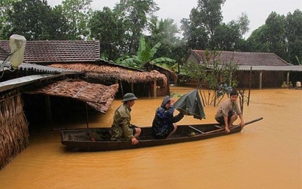 В&#039;єтнам, Хатінь. Місцеві жителі залишають свої будинки на
невеличкому човні після того, як у центральній провінції країни Хатінь
почалась повінь. Число загиблих від повені, яка спустошила центральний
В&#039;єтнам протягом останніх днів, досягло щонайменше 28 осіб. / © AFP