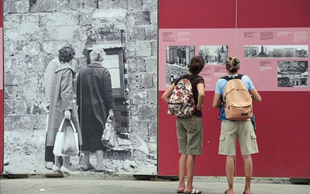 Німеччина, Берлін. Дівчата роздивляються фотографії на Берлінській стіні біля меморіалу на Бернауер-штрассе у Берліні. Мешканці Берліну відзначили 49-ту річницю зведення Берлінської стіни. / © AFP