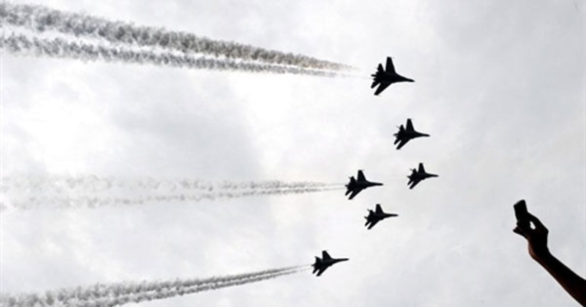 Індонезія, Джакарта. Індонезієць фотографує російський реактивний винищувач "Сухий", який маневрує під час святкування 65-річчя індонезійської армії у Джакарті. / © AFP