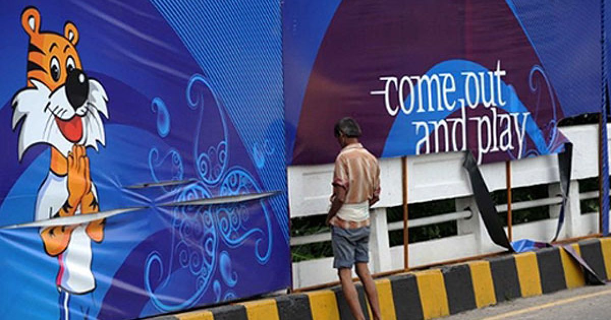 Індія, Нью-Делі. Індійський робочий мочиться перед плакатом Ігор Співдружності, які мають відбутися в Делі. Федерація Ігор Співдружності звітувала, що в Делі досягли успіху в усуненні проблем, які майже призвели до зриву спортивної події всього за 10 днів до офіційної церемонії відкриття. / © AFP