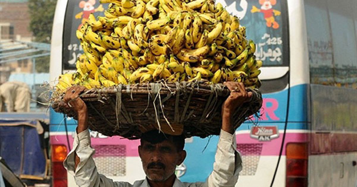 Пакистан, Лахор. Пакистанець несе велику корзину з бананами на фруктовий ринок у Лахорі. Центральний банк Пакистану підняв процентну ставку до 13,5 відсотків, попереджаючи, що інфляція, як і раніше, істотно впливає на економіку. / © AFP