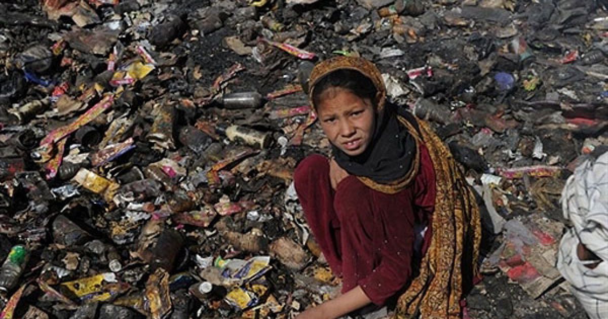 Афганістан, Кабул. Афганська дівчинка шукає пластикові та металеві вироби на звалищі на околиці Кабула. За даними Міжнародної організації GAIA, близько 15 мільйонів осіб у країнах, що розвиваються, виживають за рахунок збирання сміття. / © AFP