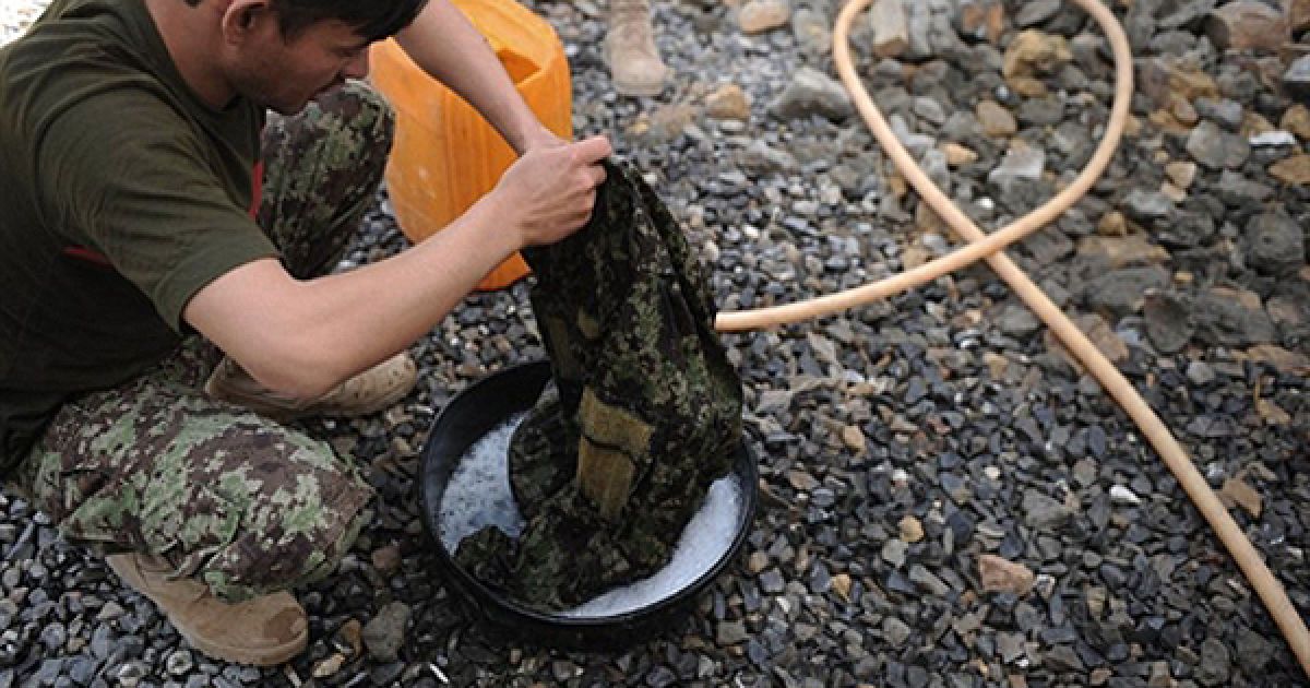 Солдат афганської національної армії пере свій одяг на військовій базі поблизу Кандагару. Вранці 13 серпня 2 американських солдатів були поранені під час вибуху саморобної бомби у Кандагарі. / © AFP