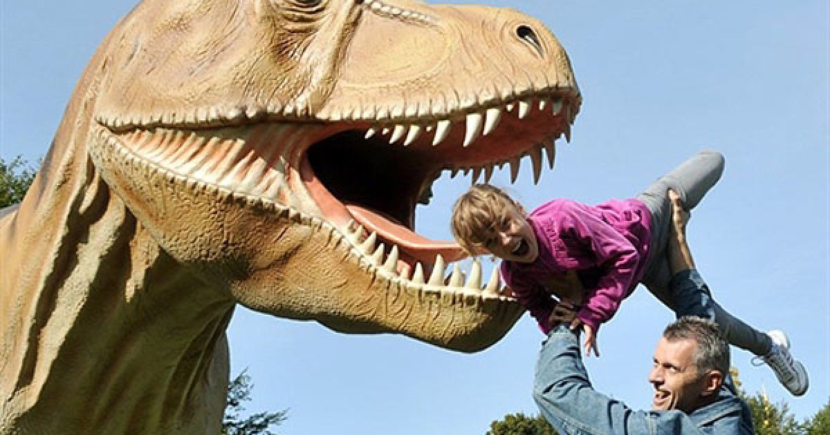 Україна, Київ. Відвідувачі виставки під відкритим небом "Світ динозаврів", яка відкрилася у Києві. Понад 10 мільйонів чоловік у всьому світі вже побачили експозицію виставки, до якої входять 62 експонати з різних країн. / © AFP