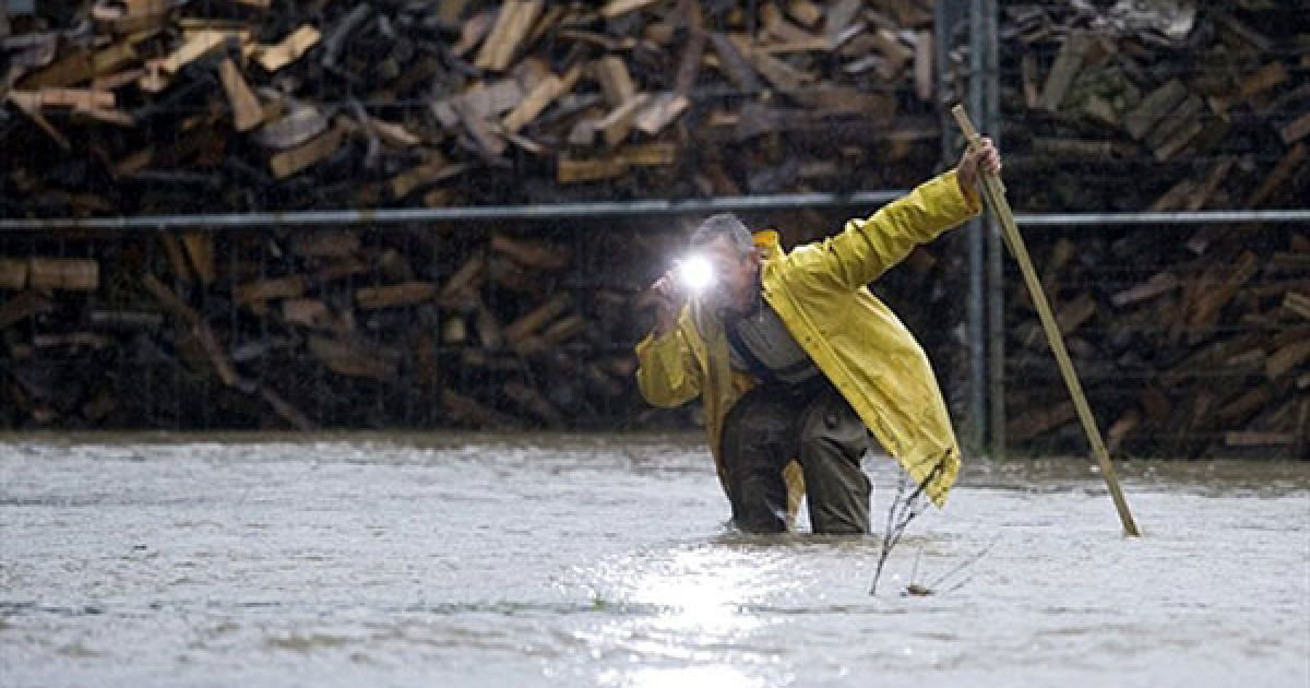 Німеччина. Чоловік робить фотографію затопленої вулиці в місті Wasserkretscham, Східна Німеччина, де вийшла з берегів річка Лоубауер. У багатьох районах Німеччини почались повені через тривалі і сильні дощі. / © AFP
