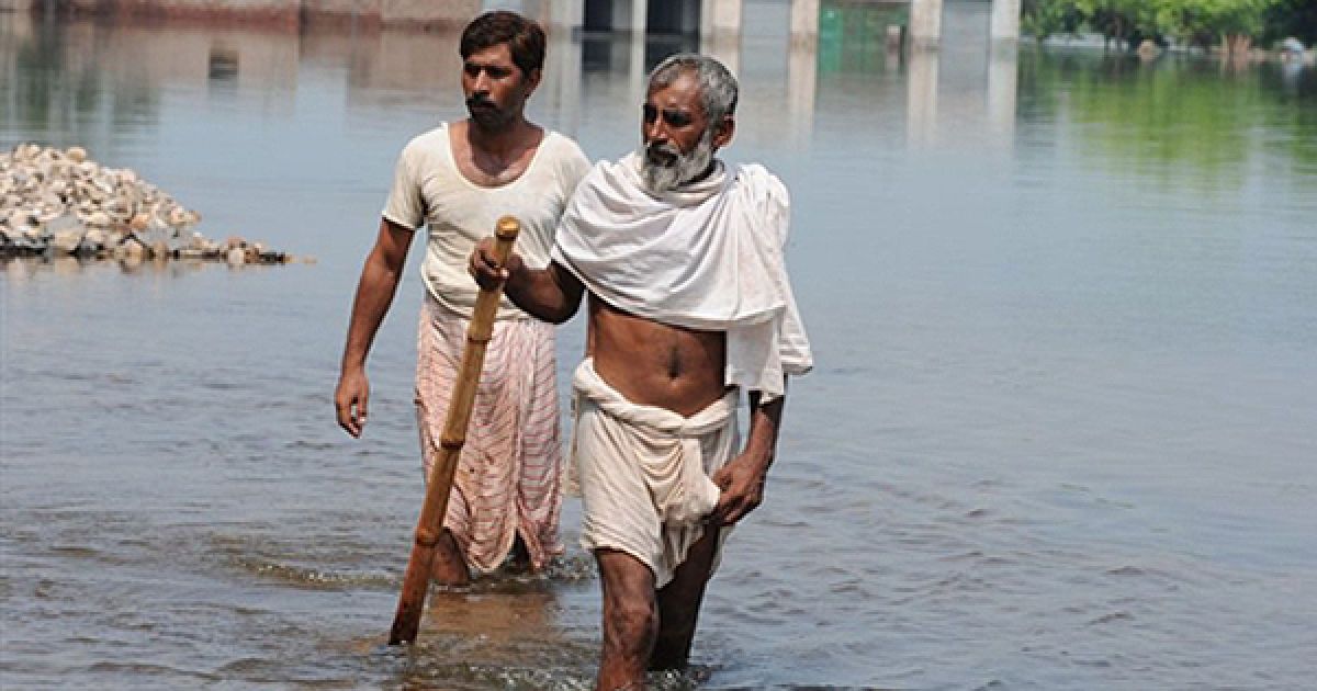 Жертви повені йдуть по затопленим вулицям пакистанського міста Джамал. Внаслідок повені економіка Пакистану, яка щойно стабілізувалася, опинилася на межі катастрофи. / © AFP
