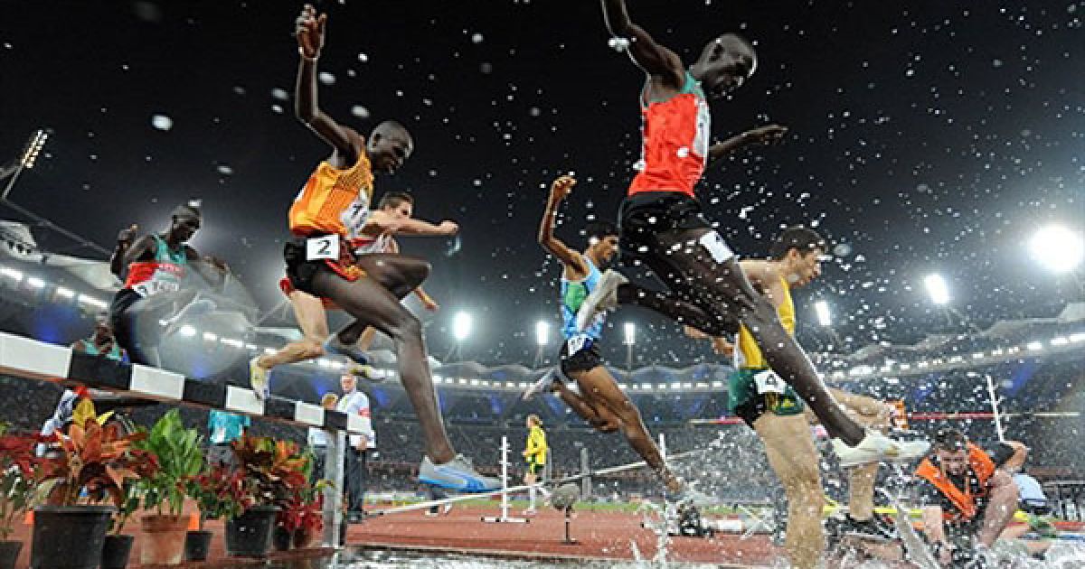 Індія, Нью-Делі. Спортсмени під час фінального забігу серед чоловіків на 3000 метрів з перешкодами на Іграх Співдружності у Нью-Делі. Золоту медаль виграв африканський чемпіон Річард Матілонг. / © AFP