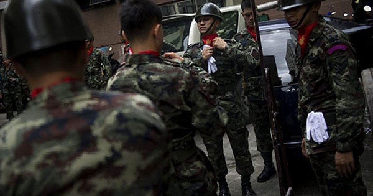 Таїланд, Бангкок. Тайський солдат приводить до ладу свою форму перед церемонією присяги новопризначеному керівнику тайської армії генералу Праюту Чан-O-Ча у штаб-квартирі тайської армії у Бангкоку. / © AFP