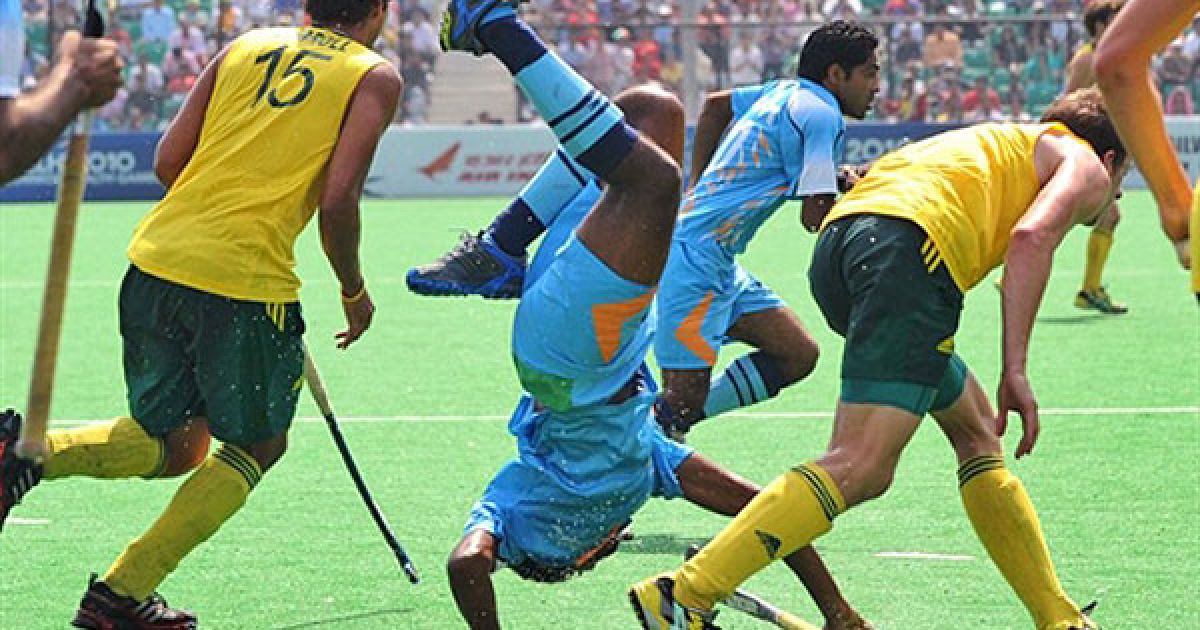 Індія, Нью-Делі. Індійський гравець Прабодх Тіркі падає після зіткнення з австралійським захисником у фіналі з хокею на траві серед чоловіків на Іграх Співдружності у Нью-Делі. Австралія виграла у Індії з рахунком 8-0. / © AFP
