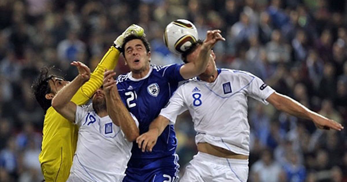 Греція, Піреус. Ізраїльський голкіпер Дуду Ауате і грецькі футболісти Авраам Пападопулос та Дократіс Папастафопулос зіткнулись під час боротьби за м&rsquo;яч у відбірковому матчі "Євро-2012" між Грецією та Ізраїлем, який відбувся на стадіоні Караїскакі у місті Піреус неподалік від Афін. / © AFP