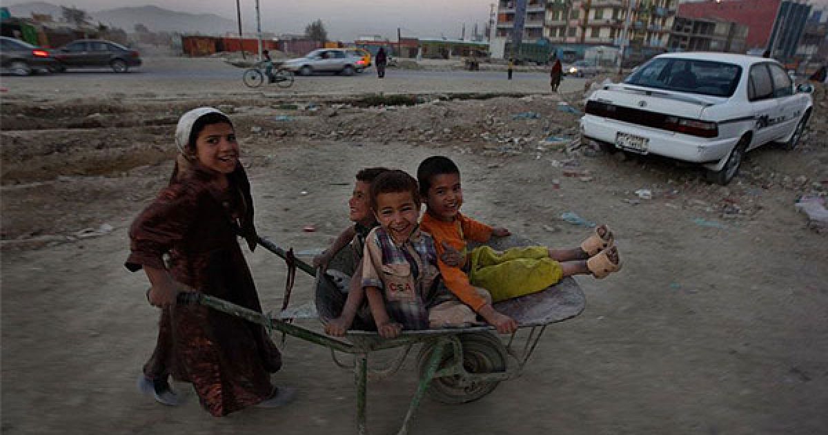 Афганістан, Кабул. Афганська дівчинка штовхає возик з трьома хлопцями у передмісті Кабула. / © bigpicture.ru