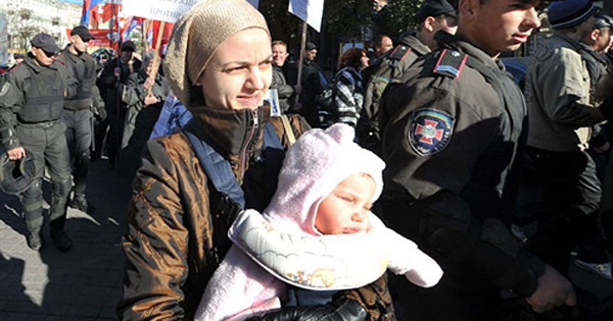 Україна, Київ. Міліціонери супроводжують колону активістів лівих партій, щоб запобігти сутичкам з ультра-націоналістами, під час відзначення 68-ої річниці з дня заснування Української повстанської армії (УПА). / © AFP