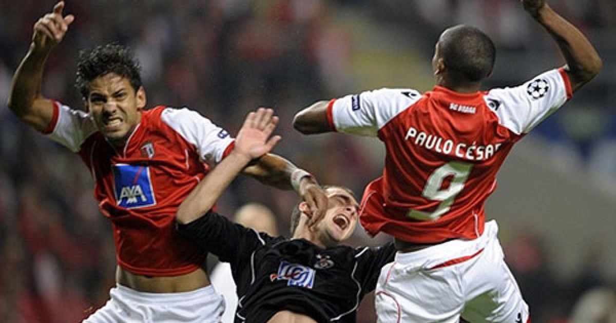 Португалія, Брага. Захисник "Браги" Мойзес Пінейро (ліворуч) і форвард "Браги" Пауло Сезар (праворуч) у боротьбі за м&rsquo;яч затиснули захисника македонського "Партизана" Олександра Лазевські під час матчу Ліги чемпіонів УЄФА. "Брага" виграла матч з рахунком 2-0. / © AFP