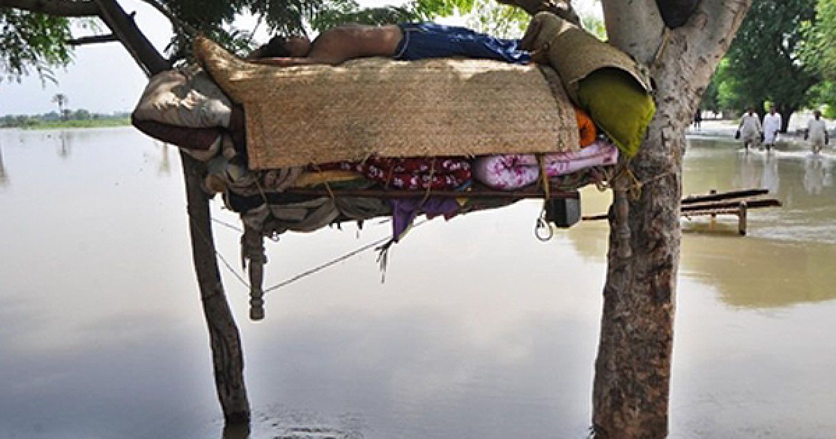 Жертва повені у Пакистані спить у гамаку над водою. За підрахунками ООН, під час повені загинули більше 1600 людей. / © AFP