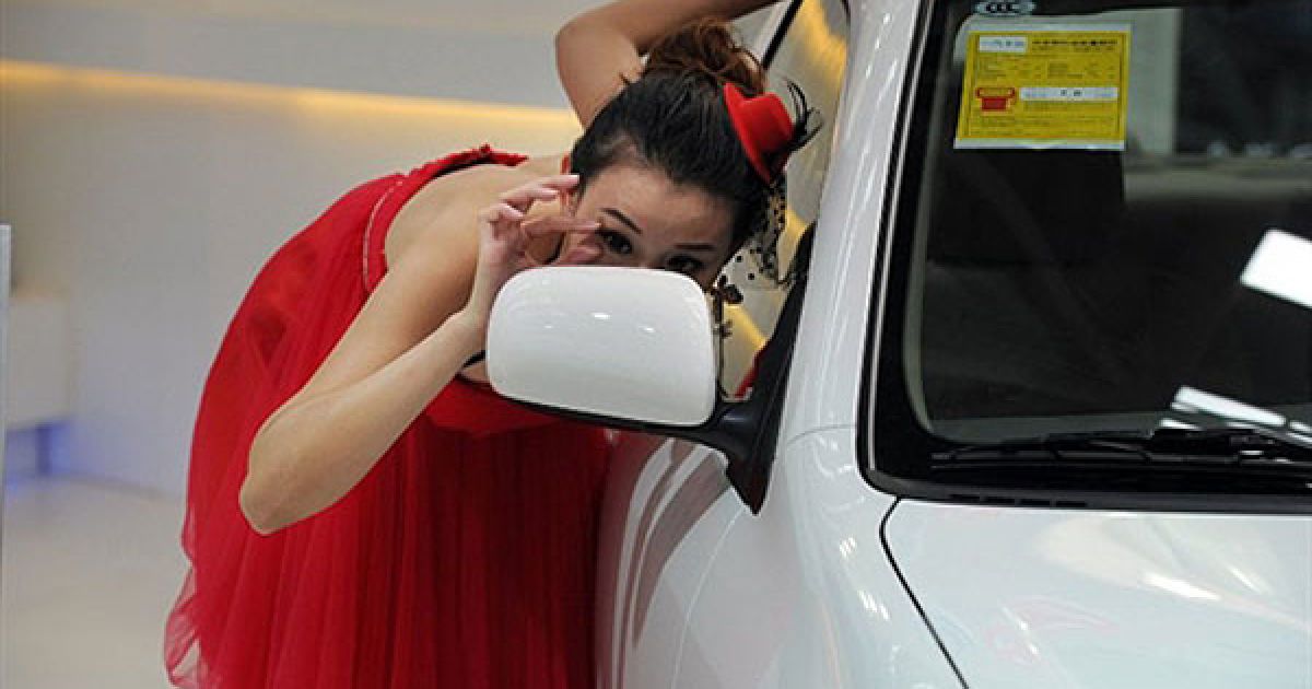 Китай, Хефей. Модель поправляє макіяж на автосалоні у місті Хефей. Продажі автомобілів у Китаї досягли 13,6 мільйонів одиниць у 2009 році, що перевищує рівень продажів у США. / © AFP