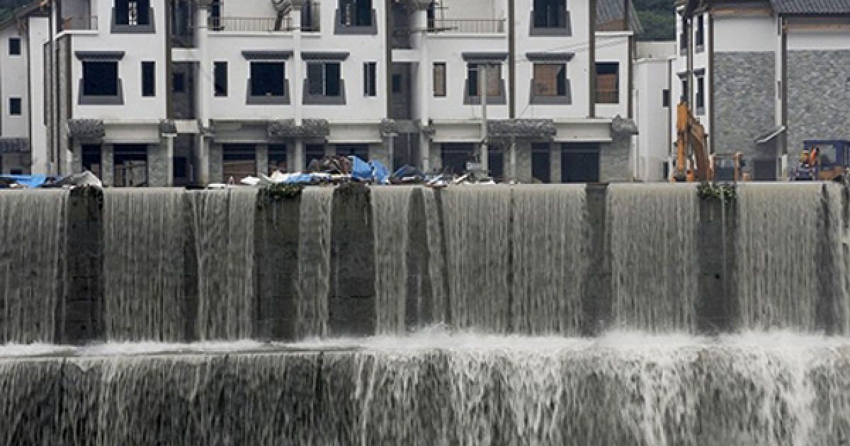 Вода стікає з затоплених вулиці міста Юнчу, яке найбільше постраждало від повені, у китайській провінції Сичуань. Під час зсуву ґрунту, який був викликаний повінню, у Юнчу загинули 15 людей. / © AFP