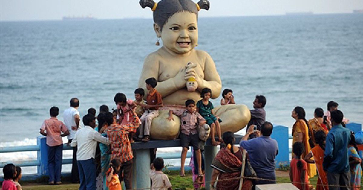 Туристи фотографуються із величезною лялькою на пляжі у Вісакхапатамі, Індія.