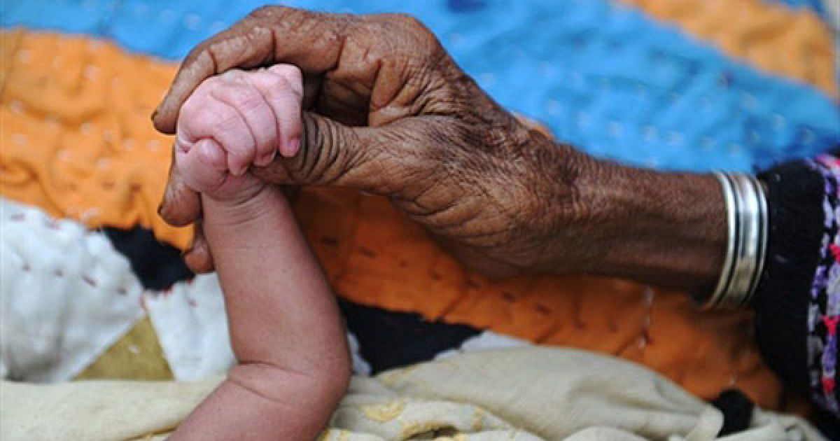 Пакистан, Суккур. Бабуся Джанал тримає за руку свого триденного онука, який народився у таборі біженців для пакистанців, переміщених всередині країни через повені. Руйнівні повені у Пакистані залишили більше 10 мільйонів людей без даху над головою. / © AFP