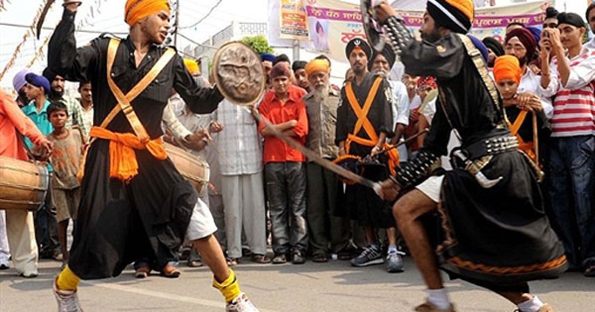 Індія, Амрітсар. Індійські сикхи, одягнені у костюми релігійних воїнів сикхів &ldquo;nihang&rdquo;, демонструють свою майстерність у бойовому мистецтві сикхів, відомому як "gatka&rdquo; під час ходи до Золотого храму в Амрітсарі. В Індії готуються до святкування дня народження четвертого Гуру сикхів Рамдасса, який народився у Лахорі у 1574 році. / © AFP