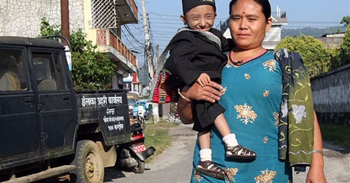 Мати з сином йде вулицею селища Похара / © AFP