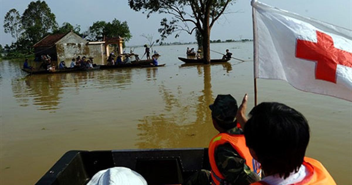 В'єтнам, Нам Дан. Рятувальна команда Червоного Хреста на човні, завантаженому локшиною швидкого приготування і чистою водою, наближається до групи жителів, які очікують на гуманітарну допомогу у районі Нам Дан, який сильно постраждав від повені. Число загиблих в результаті повеней у центральному В'єтнамі зросло до 58 осіб. / © AFP