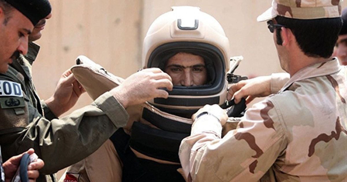 Експерти з вибухових речовин допомагають своєму колезі одягнути захисний костюм під час навчань, організованих армією США, у Баакубі. / © AFP