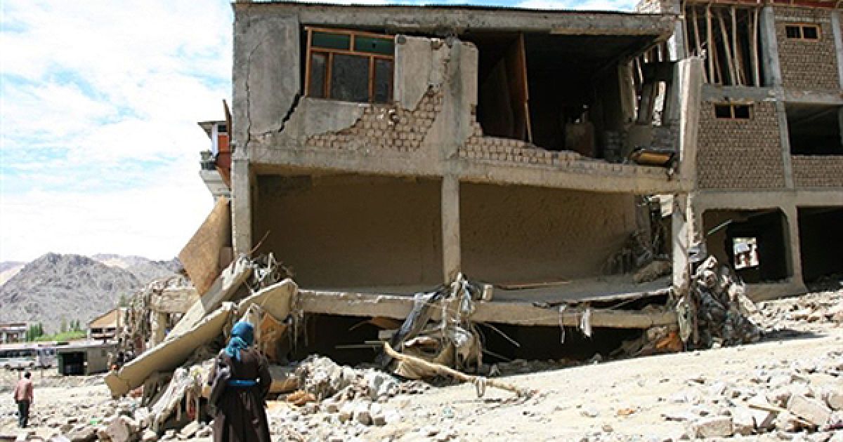 Жінка оглядає руїни свого будинку, який було зруйновано повінню, у Гімалаях, Індія. Тільки протягом 13 серпня з цього району були евакуйовані 172 туристи, які не могли вибратися з гірського району через повінь та зсуви ґрунту. Всього внаслідок повені загинули 185 людей. / © AFP