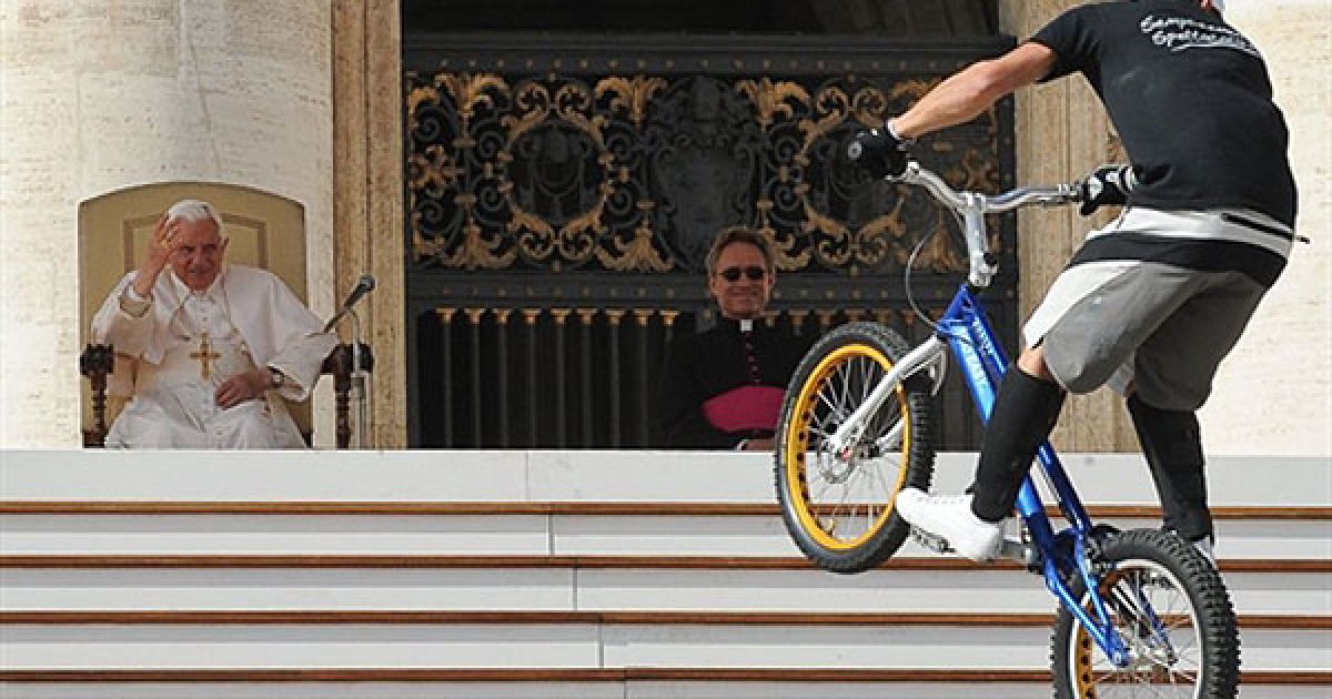 Ватикан. Папа Римський Бенедикт XVI вітає члена Міжнародного циркового фестивалю, який заїхав на сходи собору Святого Петра на велосипеді BMX під час щотижневої аудієнції понтифіка на площі Святого Петра у Ватикані. / © AFP