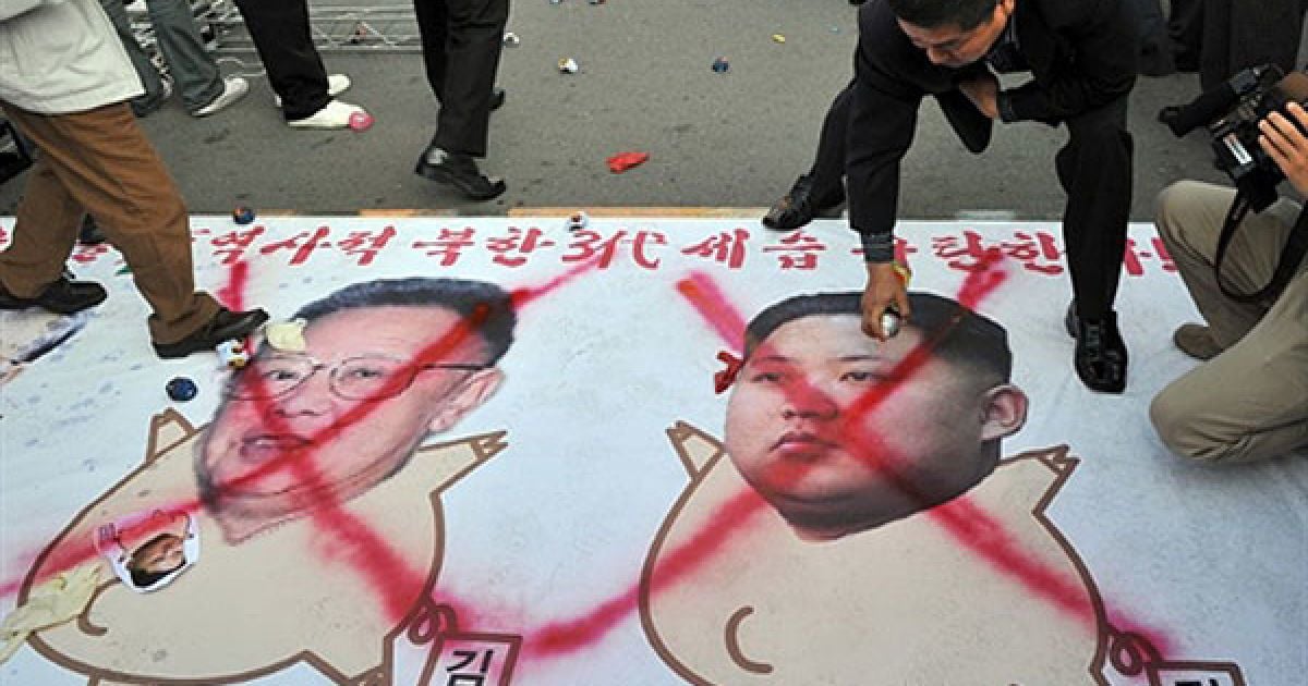 Республіка Корея, Сеул. Південнокорейські активісти малюють червоні хрести на карикатурах лідера Північної Кореї Кім Чен Іра та його молодшого сина Кім Чен Ина під час мітингу, на якому було засуджено "комуністичну династію", що вже три покоління керує Північною Кореєю. Північна Корея офіційно назвала Кім Чен Ина наступним лідером, який займе місце свого хворого батька. / © AFP