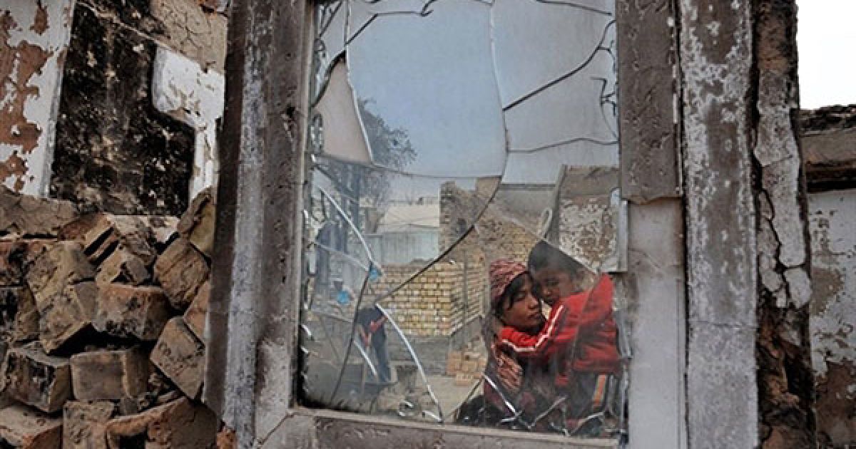 Киргизстан, Ош. Узбецька жінка та її син дивляться на свій зруйнований будинок у селі Шарк неподалік від міста Ош. Сили безпеки у Киргизстані перебувають у стані підвищеної готовності, аби уникнути спалаху насильства напередодні парламентських виборів в країні. Президент Киргизстану Роза Отунбаєва заявила, що країна намагається оправитися від етнічного кровопролиття. / © AFP