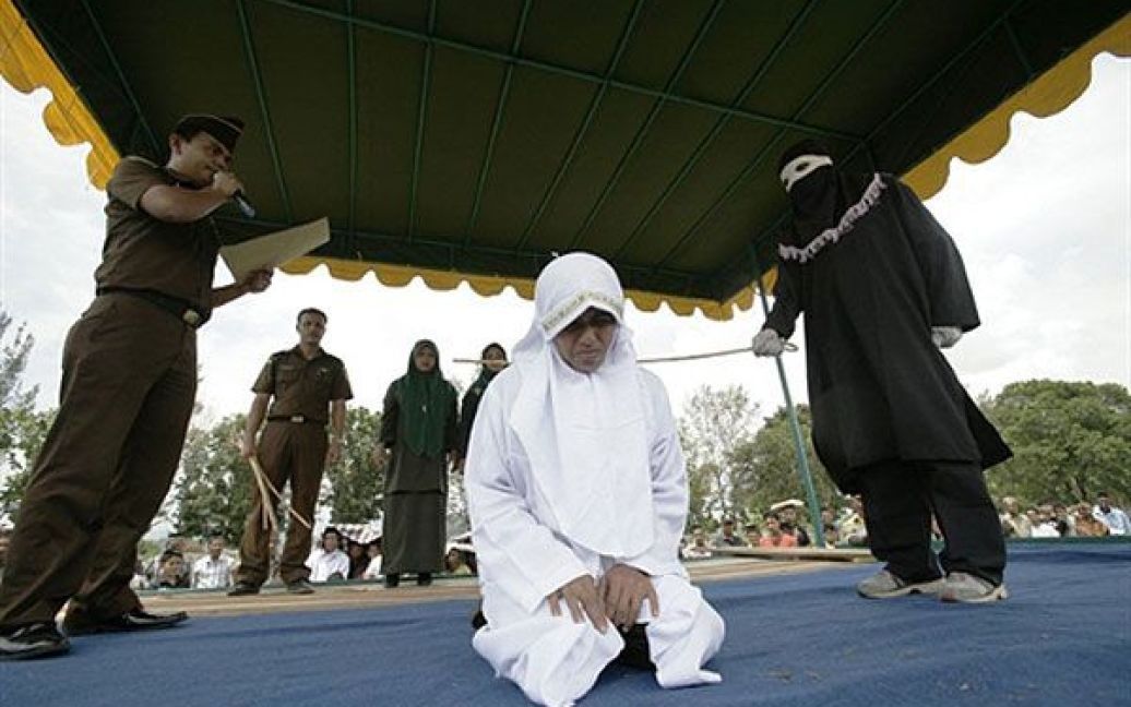Індонезія. Індонезійські офіційні представники шаріату лупцюють батогами жінку, яку спіймали на позашлюбному зв&#039;язку. / © AFP